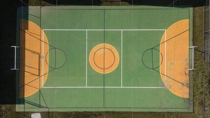 Multi-sport court (volleyball, futsal and basketball), in green and yellow, covered with net and a...