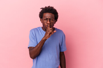 Young african american man isolated on pink background keeping a secret or asking for silence.