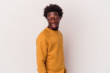 Fototapeta premium Young african american man isolated on white background looks aside smiling, cheerful and pleasant.