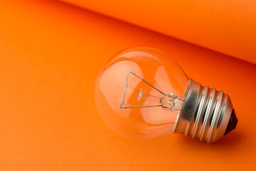 Light bulb on the orange table. Electrical appliance