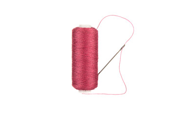 Needle and thread is stuck in an overlock spool with red threads.