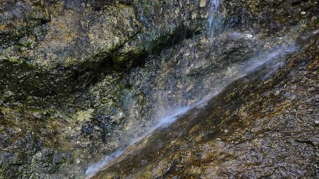 Small waterfall on large stone in Austrian Alps, klausbach river, valley near attersee