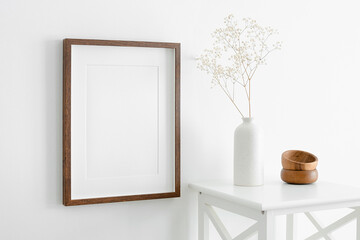 Portrait wooden frame mockup for artwork, photo and print presentation. White walll interior with...