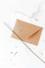 Blank paper sheet and craft envelope with empty copy space for text on white background. Flat lay, top view. Mail, letter and invitation concept.