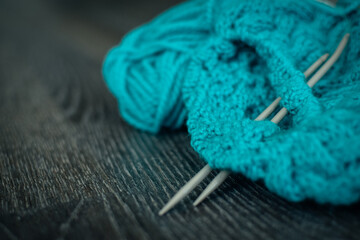 knitted products blue with knitting needles on a dark background