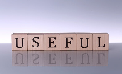 USEFUL concept, wooden word block on the grey background