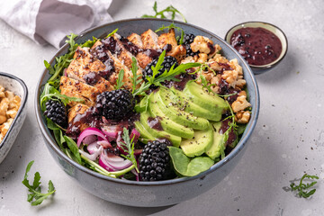 Grilled chicken breast, fillet and fresh vegetable salad of lettuce, arugula, spinach, avocado, onion and walnut with blackberry dressing. Healthy lunch menu. Diet food. Top view