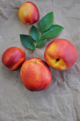 Nectarine. Ripe juicy organic nectarines (peaches). Close-up. Whole fruits on craft paper. Healthy food concept. Vegetarianism. View from above. Copy space.