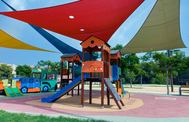 Playground in city park with colorful awnings for sun protection