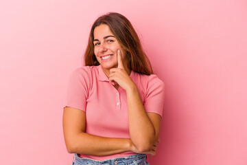 Young caucasian woman isolated on pink background  smiling happy and confident, touching chin with hand.