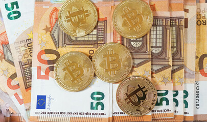 Monedas de Bitcoin o criptomonedas con dinero real en euros de fondo y microprocesadores de ordenador para validar la fuerza del minado de criptomonedas como activos financieros.