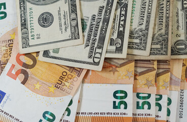 Fototapeta na wymiar Billetes de 50 euros y dólares de 20 y 10 enfrentados con toma de primer plano