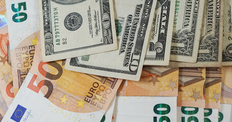 Fototapeta na wymiar Billetes de 50 euros y dólares de 20 y 10 enfrentados con toma de primer plano
