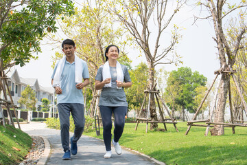 Asian senior couple running together in the morning at park. healthy lifestyle people exercise for...