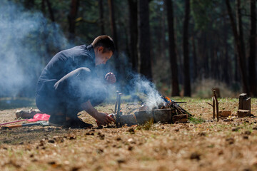 a man lights a fire. family vacation in nature