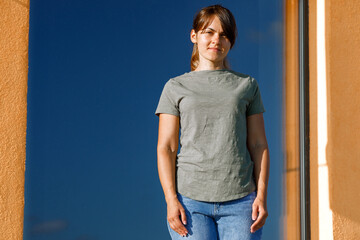 Girl wearing green blank t-shirt with space for your logo, mock up or design in urban area