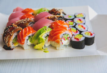 Tasty Colorful assorted Set of different type Sushi. Dinner in Japanese style. Healthy food concept. Filadelfia and Maki sushi rolls with Avocado, Tuna, Salmon, fish and Prawns. Vegetarian food.