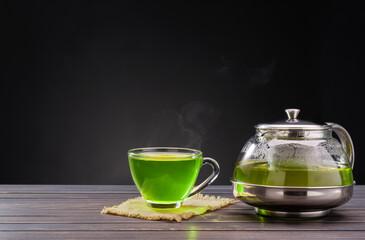 Organic Fresh Green Tea hot green tea placed on wooden table on black background