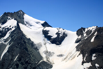 Snowcapped rocky summit at altitude in Savoy. Mountain landscape in the Alps with glaciers.