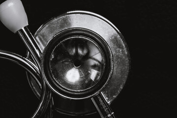 The stethoscope is placed on a black background.black and white.