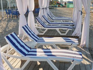 Sunbeds on the beach are waiting for vacationers. Summer vacation at sea.
