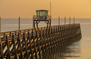 Luc-Sur-Mer, France - 08 05 2021:  Colorful sunrise on the sea and the fishermen's jetty from the...