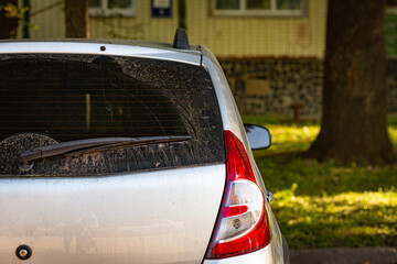 Back window of grey car parked on the street in summer sunny day, rear view. Mock-up for sticker or decals