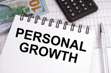 On the table there is money, a calculator and a notebook with the inscription - PERSONAL GROWTH