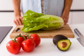 Young mixed race man preparing a salad for lunch