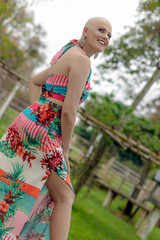 Beautiful and strong woman fighting breast cancer Smiling and happy. Hairless and bald. live and joy of fighting. Sensual dress of flowers in nature. On the ranch.