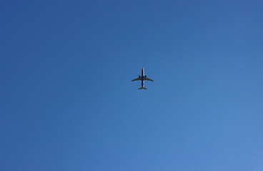 Airplane flying high in the deep blue sky