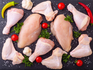 Assortment of raw chicken  breast ( fillet ) , wings and legs  with spices and herbs