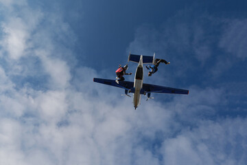 Fototapeta na wymiar Skydiving. Freefly jump. Two guys are faling in the cloudy sky.