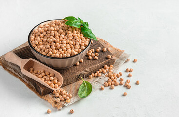 A bowl with dry, raw chickpeas on a gray background. Side view, space for copying. Healthy, organic food.