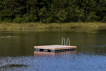 Swimming raft with ladder in the middle of a lake. Shot in Sweden, Scandinavia