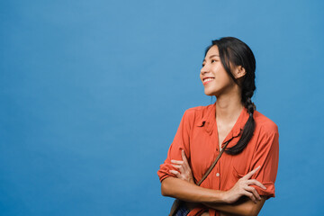 Portrait of young Asia lady with positive expression, arms crossed, smile broadly, dressed in casual cloth over blue background. Happy adorable glad woman rejoices success. Facial expression concept.