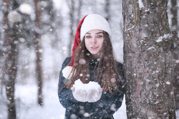 Girl in a winter park in snowfall