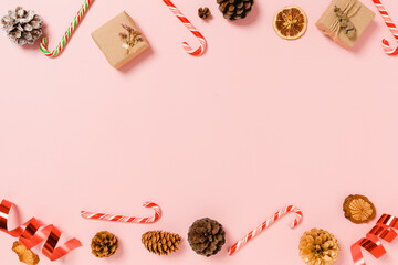 Minimal creative flat lay of christmas traditional composition and new year holiday season. Top view winter christmas decorations on pink background with blank space for text. Copy space photography.