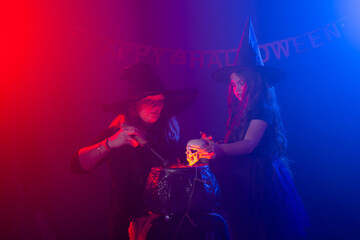 Fototapeta na wymiar Funny child girl and woman in witches costumes for Halloween.