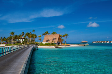 hard rock hotel buildings with palms against the background of emerald water. Crossroads Maldives, july 2021