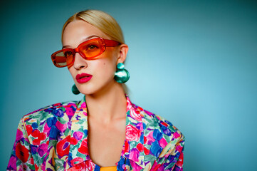 Summer fashion portrait of beautiful confident woman wearing trendy orange sunglasses, green shell...