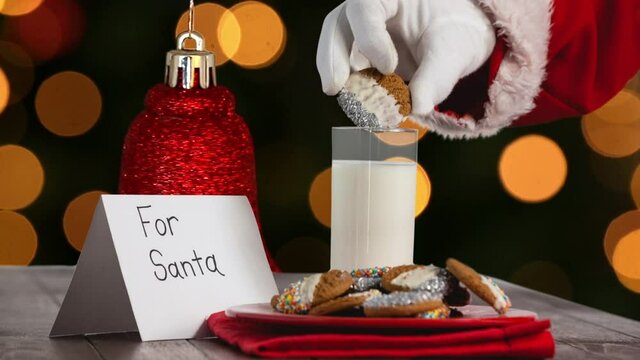 Animation of santa claus picking cookies over orange spots of light