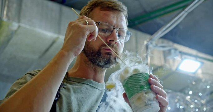 close-up of a man who tries an experimental dessert made with liquid nitrogen