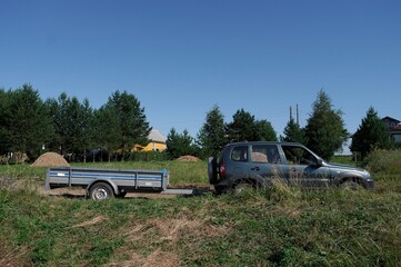 Fototapeta premium off-road vehicle with trailer in the countryside