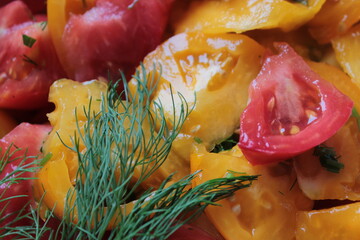 Salad of red and yellow tomatoes and dill.