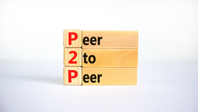 P2P, peer to peer symbol. Wooden blocks with concept words 'P2P, peer to peer'. Beautiful white background, copy space. Business and P2P, peer to peer concept.