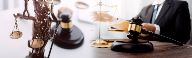 Justice and law concept.Male judge in a courtroom with the gavel, working with, computer and docking keyboard, eyeglasses, on table in morning light