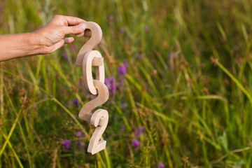 Obraz premium women's hands hold wooden numbers 2022 against the background of green grass. climate change. ecology. Happy New Year concept