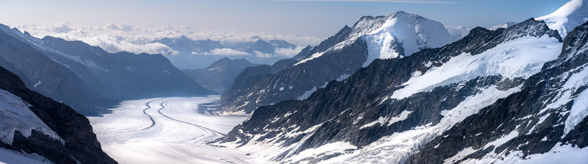Fototapeta na wymiar vue panoramique sur un large glacier bordé de chaine montagneuses et enneigées