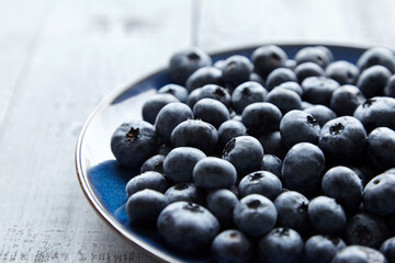 Blueberries on blue plate on wooden table